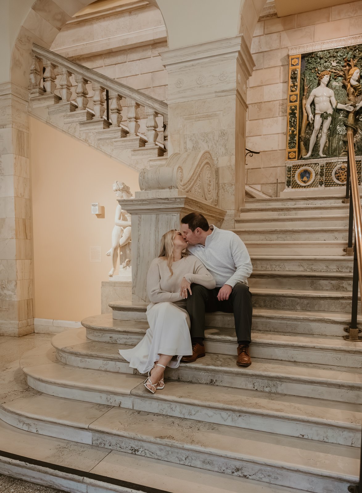 Karley and Michael kissing on a grand marble staircase